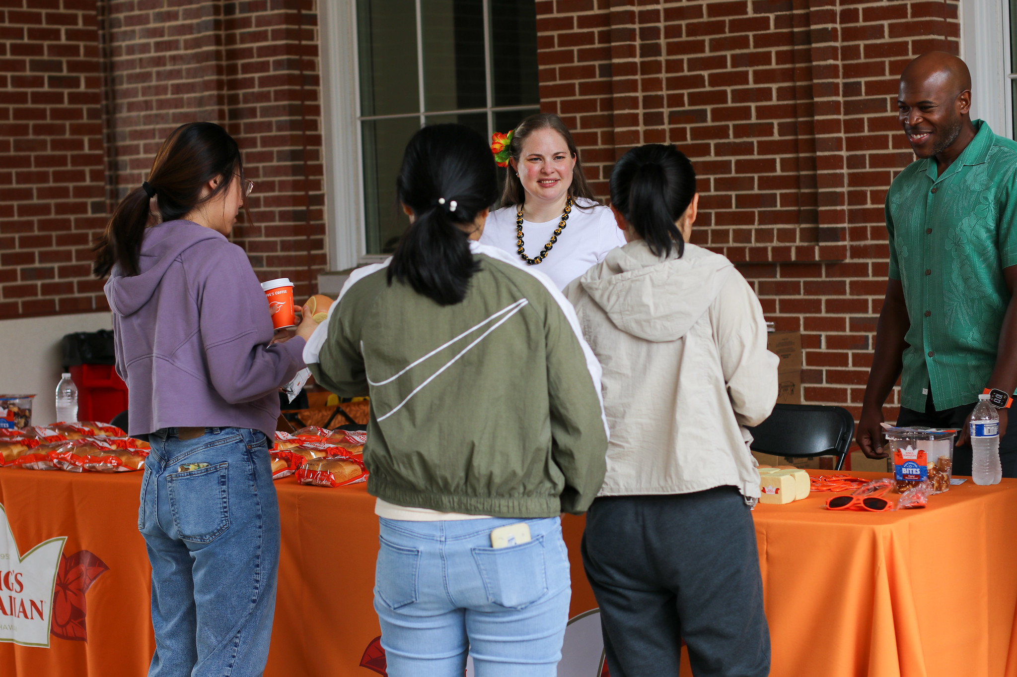 Dr. Morkos speaking to a group of people while standing by a large machine.